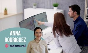 Personas analizando datos en pantalla doble, oficina moderna. Texto: “Anna Rodriguez" y "Adsmurai”. Palabras clave: análisis de datos, marketing digital.