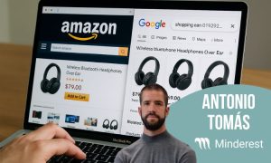 Una pantalla de un portátil con dos pestañas abiertas: una de Amazon y otra de Google Shopping, ambas mostrando auriculares inalámbricos. En Amazon, el precio está en $79.00, mientras que en Google Shopping se comparan precios de diferentes vendedores. En primer plano, aparece un hombre con barba, identificado como Antonio Tomás de Minderest, junto al logo de la empresa. La composición refleja el análisis de precios entre plataformas de eCommerce.