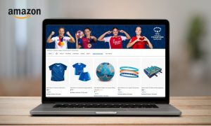 Imagen de un ordenador portátil sobre un escritorio. En la pantalla del ordenador aparece la tienda oficial de la UEFA Women’s Champions League en Amazon. En la esquina superior izquierda de la pantalla se ve el logo de Amazon