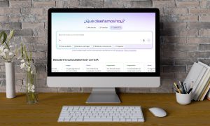 Imagen de un ordenador de mesa sobre un escritorio ordenado. En la pantalla del ordenador se ve la ventana de inicio de Canva IA