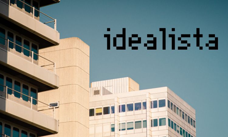 Edificios modernos contra cielo azul, destacando el texto "idealista" en negrita. Ideal para promocionar bienes raíces y urbanismo.