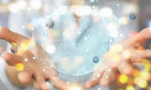 Manos sostienen un globo digital brillante, rodeado de partículas flotantes; representa innovación tecnológica y conectividad en un entorno futurista.