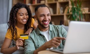 Dos personas, una mujer y un hombre, utilizan un ordenador para comprar online en un marketplace en España