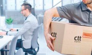 repartidor de ctt express con un paquete en una oficina