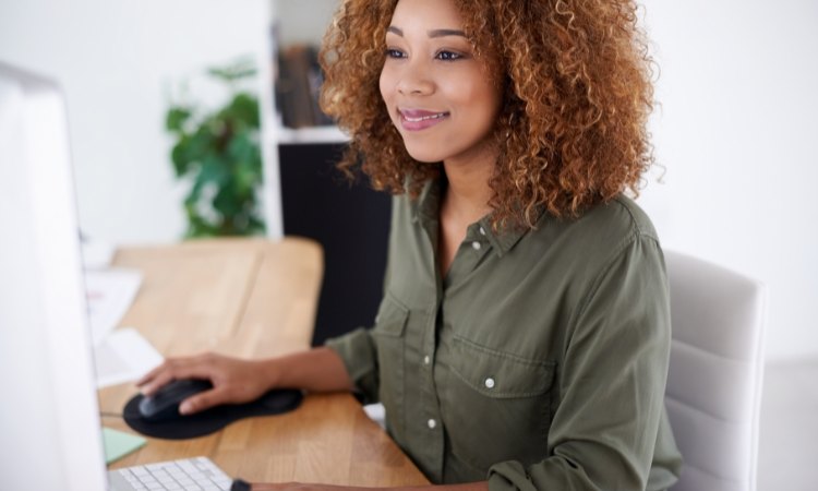 Una mujer frente a su PC trabajando en email marketing automation.