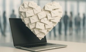 de un ordenador emerge una nube de montones de sobres de correo. a lo lejos, se ve gente difuminada