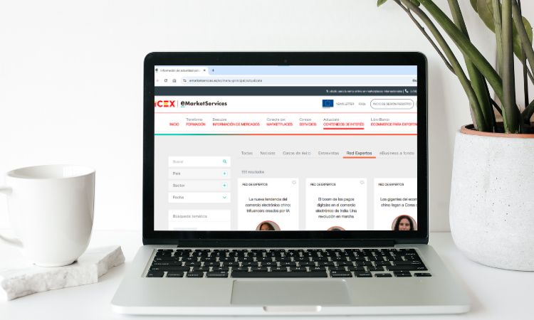 Portátil mostrando página web sobre educación continua, rodeado de una taza y planta sobre mesa blanca. Texto: "Planificación estratégica en las organizaciones".