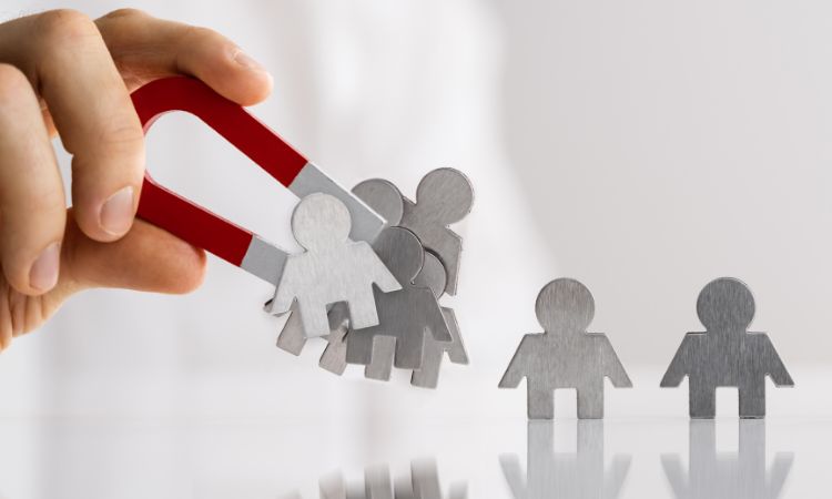 Imagen de un imán atrayendo monigotes de metal, ilustrando las 5 estrategias de captación de leads para startups.
