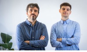 Imagen de Enrique Tejedo, CEO de Kenji Marketing y su compañero de trabajo posando serios a cámara con los brazos cruzados.