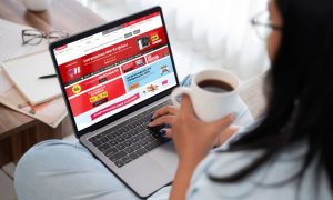 Fotografía de una mujer utilizando su ordenador portátil para acceder al marketplace de Eroski