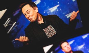 Fotografía de Elon Musk con los pulgares hacia arriba y gesto de sonrisa burlona en la cara