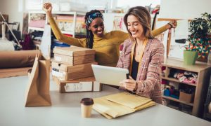 Imagen de dos emprendedoras gestionando con éxito pedidos de su tienda online, integrando canales omnicanal y optimizando el Lifetime Value (LTV).