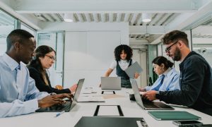 Fotografía de un grupo de trabajadores y trabajadoras reunidos en una sala para trabajar en un proyecto de comunicación