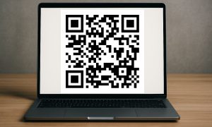 crea una imagen en formato 16:9 de un ordenador en el que en su pantalla se ve un gran código qr