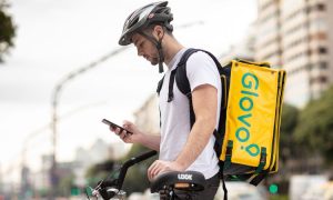 repartidor de glovo mirando el móvil