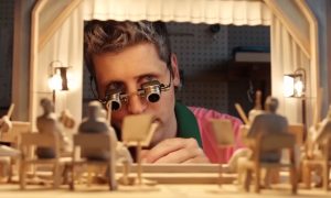 Fotograma de un vídeo generado con Sora 2 en el que aparece Sam Altman observando un pequeño teatro de marionetas que componen una orquesta