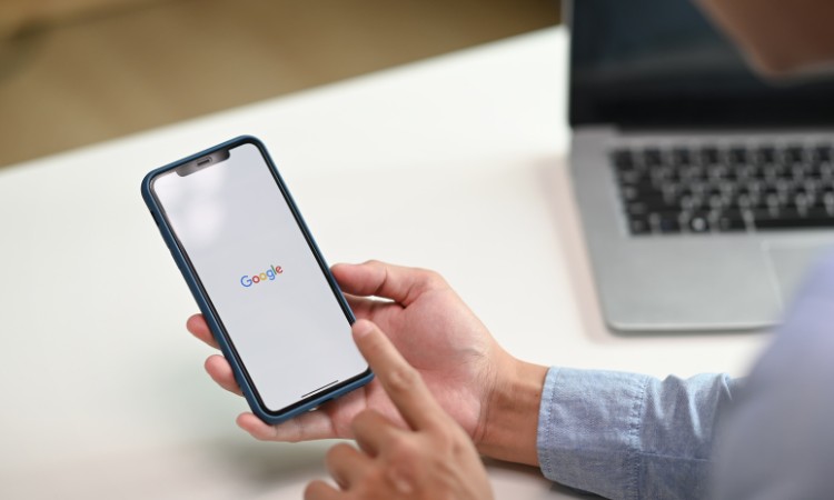 Imagen de unas manos sujetando un móvil, en el móvil podemos ver el logo de Google. Esta imagen ilustra las tendencias SEO de la mano de SiteGround.